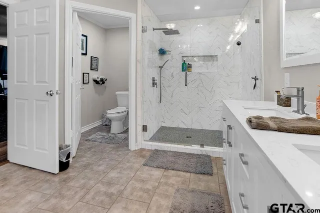 a spacious bathroom with a double vanity sink a large mirror and a large window