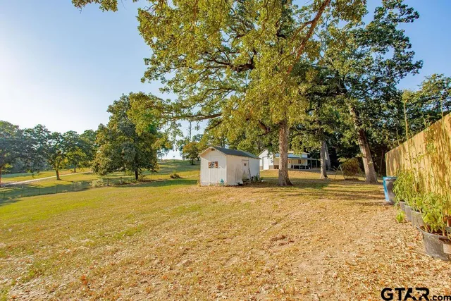 a view of yard with swimming pool and green space