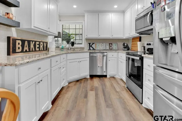 a kitchen with cabinets appliances and a sink