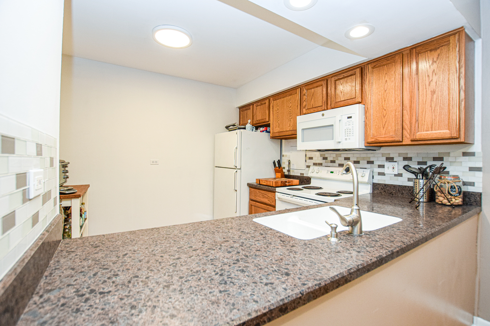 1802 Plum Grove Road, Unit 2A Rolling Meadows, IL 60008 - Photo 7 of 19 a kitchen with sink refrigerator and microwave