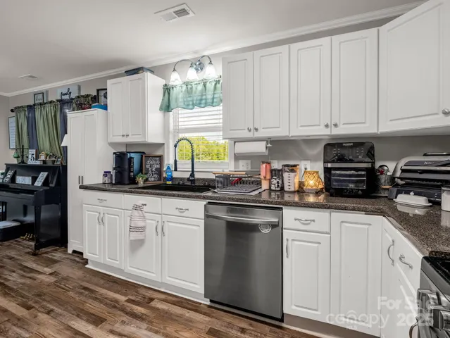 a kitchen with cabinets appliances a sink and a window