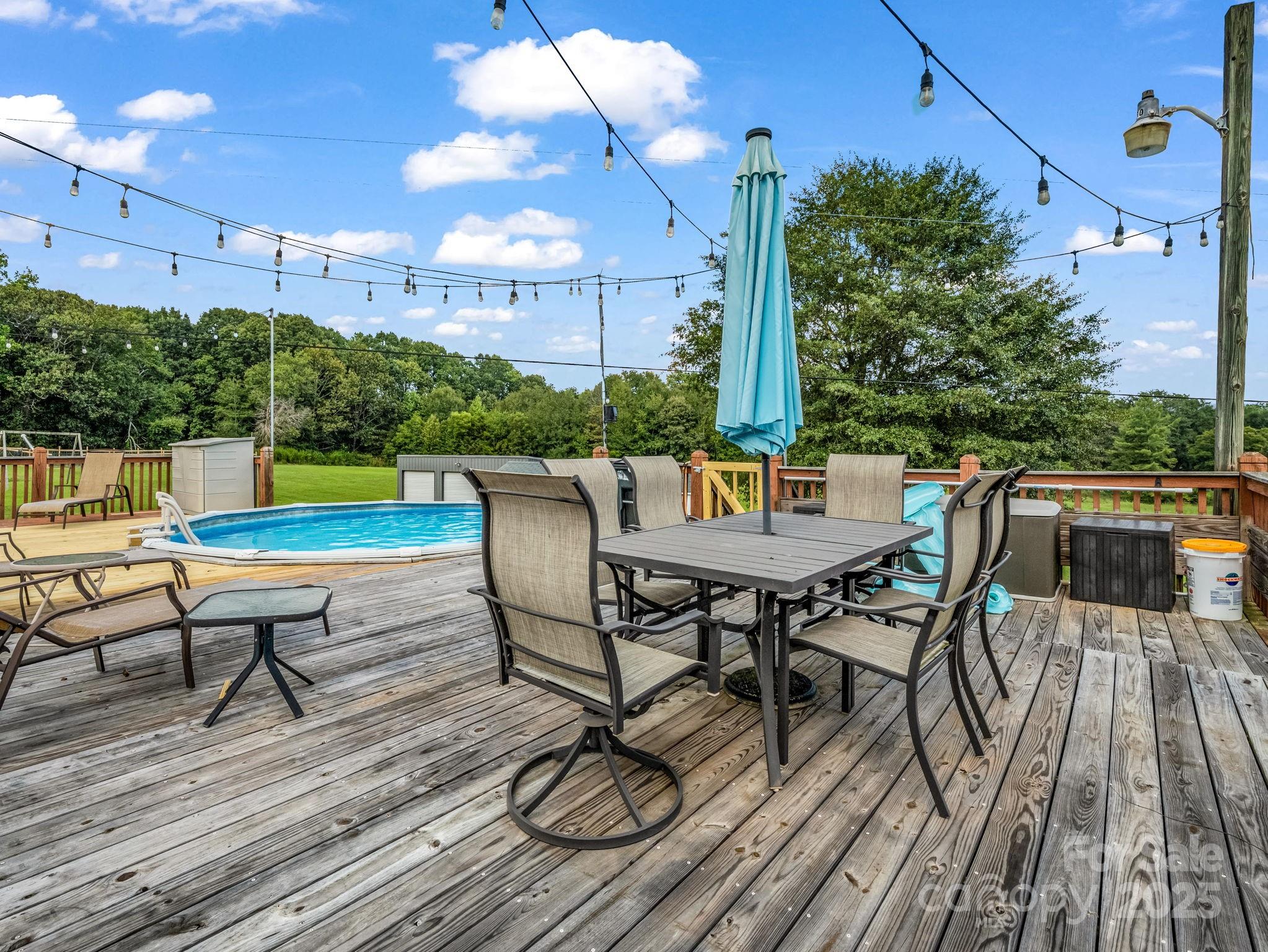 261 Faye Toney Road Mooresboro, NC 28114 - Photo 31 of 48 a view of a patio with table and chairs with wooden floor and fence