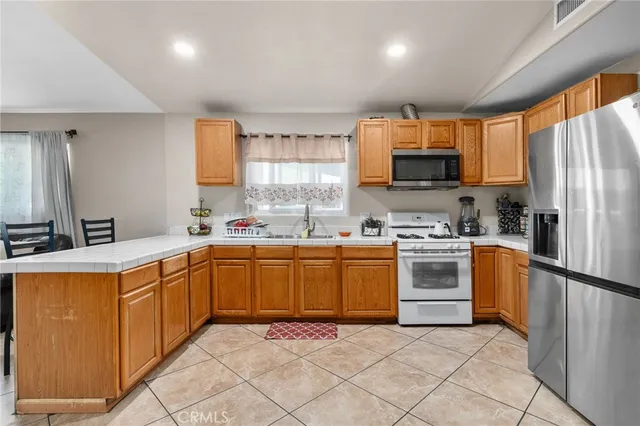 a kitchen with granite countertop a sink stainless steel appliances and cabinets