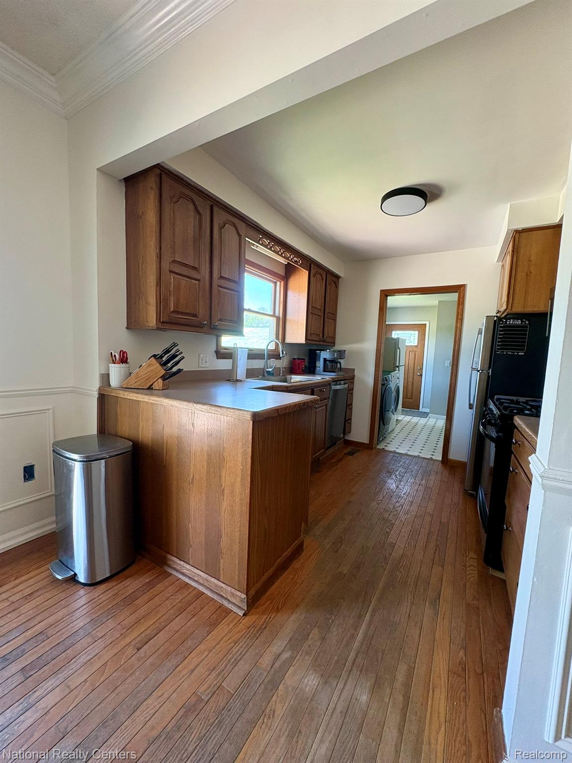 10667 West Sober Road Webberville, MI 48892 - Photo 14 of 28 Kitchen featuring wood-finish flooring, wood cabinetry, and a stainless steel sink with a gooseneck faucet