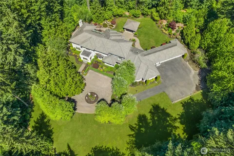 an aerial view of residential house with yard and swimming pool