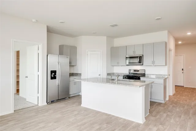 a kitchen with stainless steel appliances a refrigerator stove microwave and sink