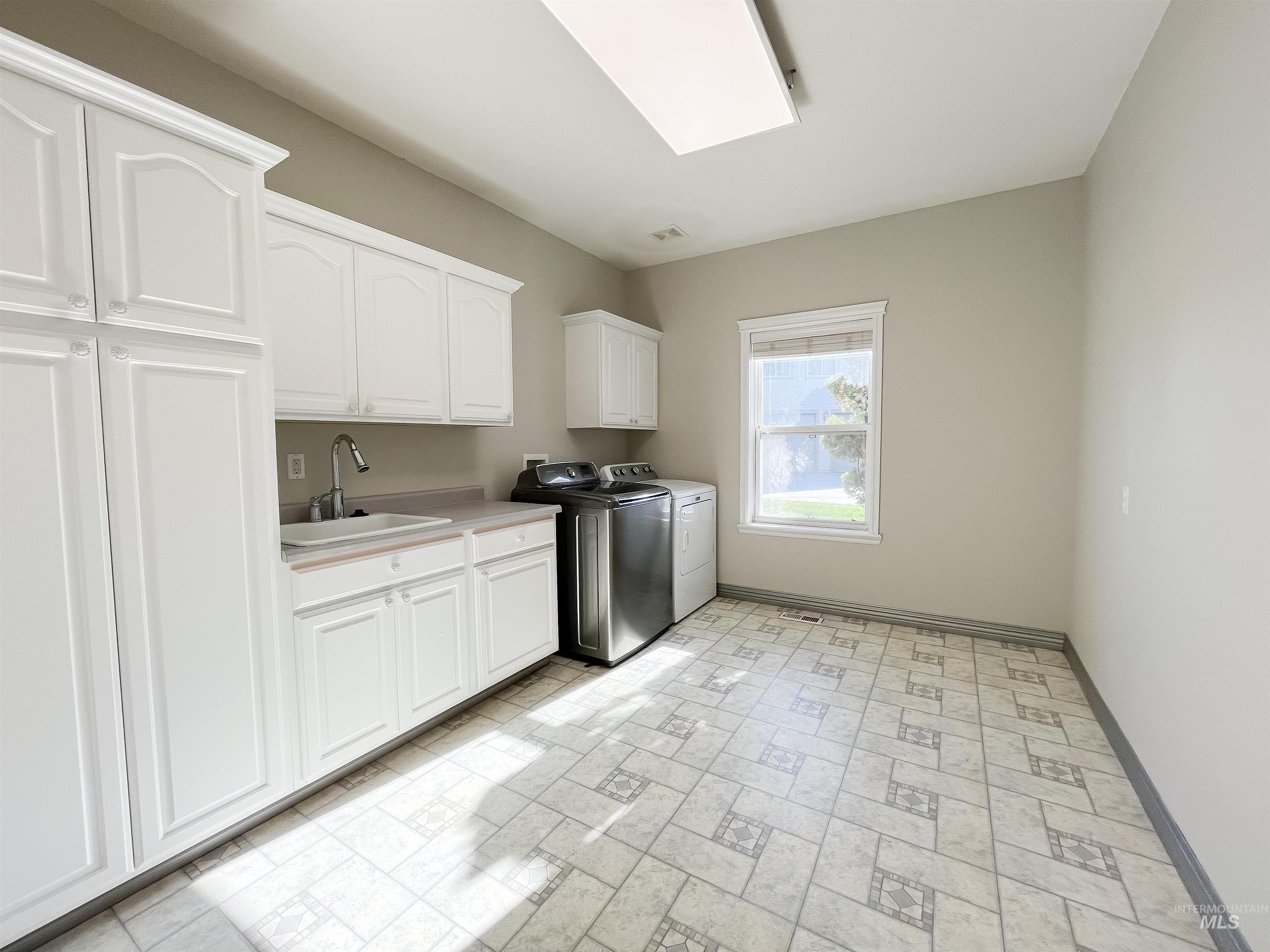 5231 North Morninggale Way Boise, ID 83713 - Photo 16 of 44 Laundry room featuring cabinet space, separate washer and dryer, and a skylight