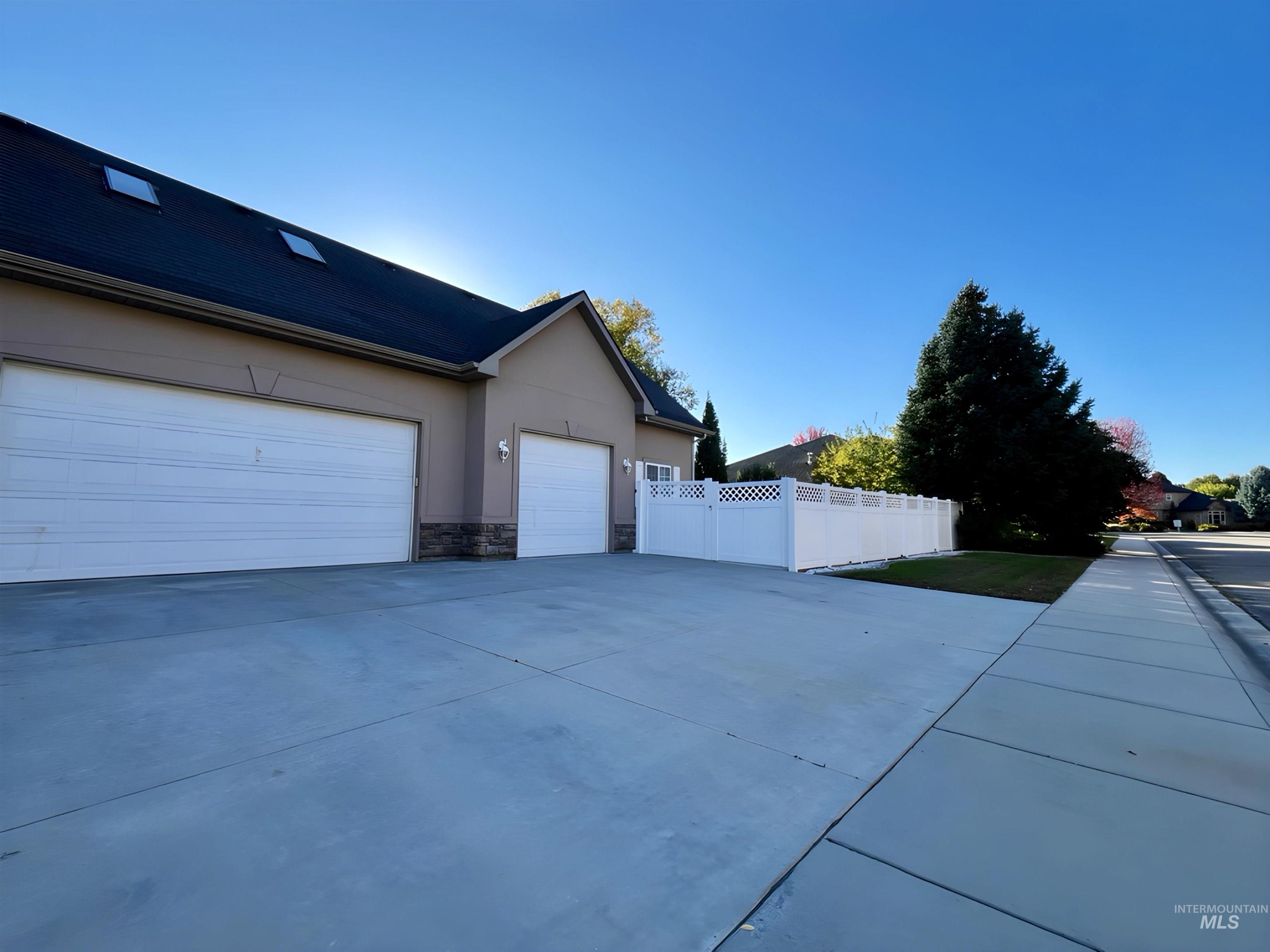5231 North Morninggale Way Boise, ID 83713 - Photo 29 of 44 View of home's exterior featuring driveway, stone siding, and stucco siding