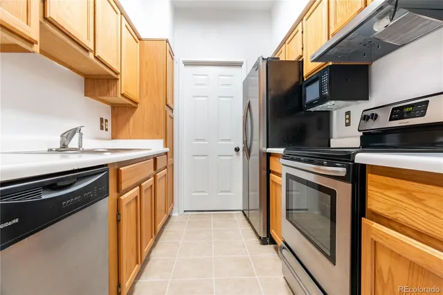 a utility room with stainless steel appliances a stove and a refrigerator