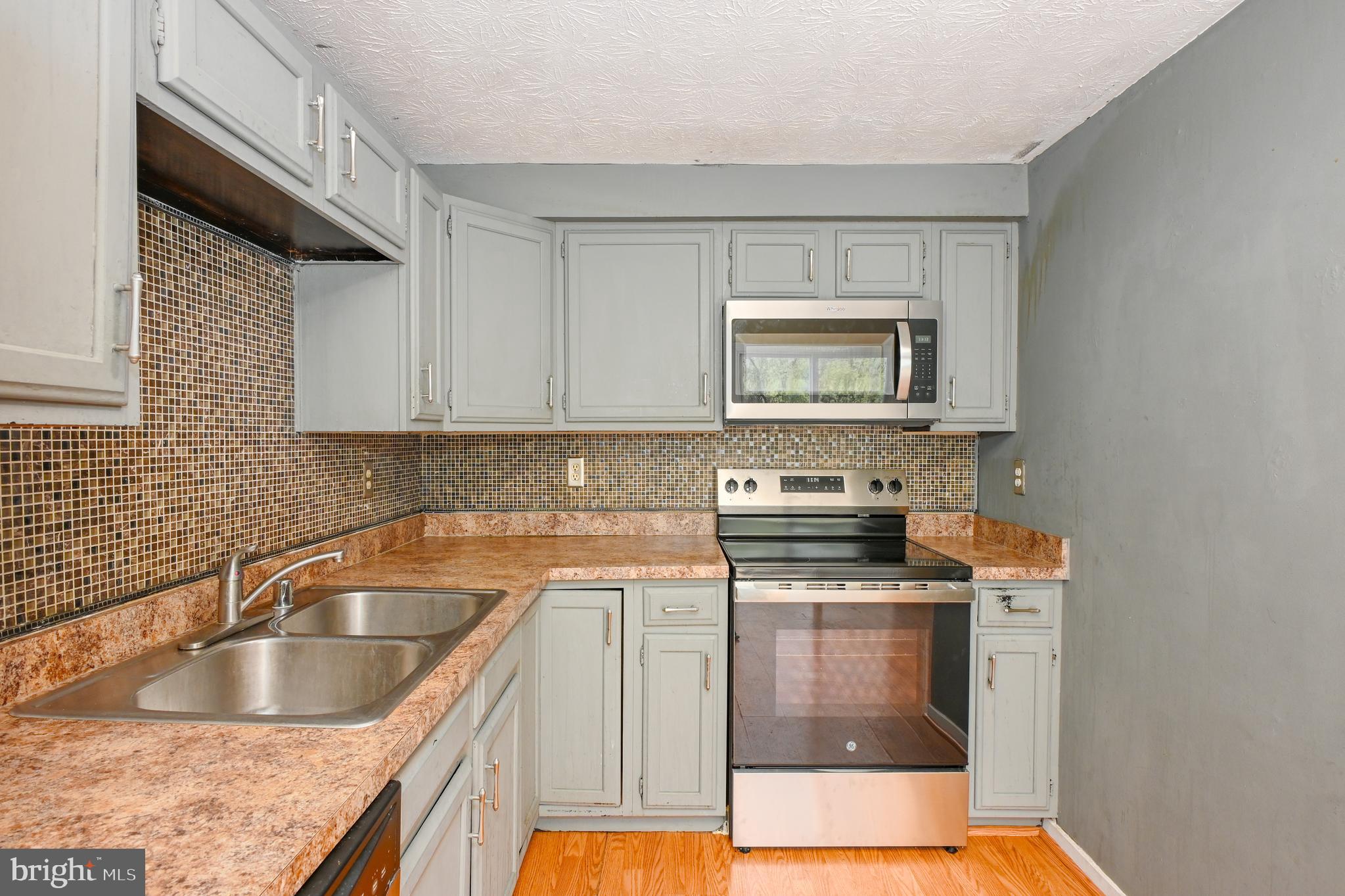 22 Morning Court Rosedale, MD 21237 - Photo 11 of 42 a kitchen with granite countertop a sink a stove and cabinets