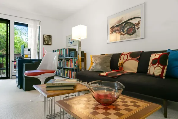 a living room with furniture a flat screen tv and a floor to ceiling window