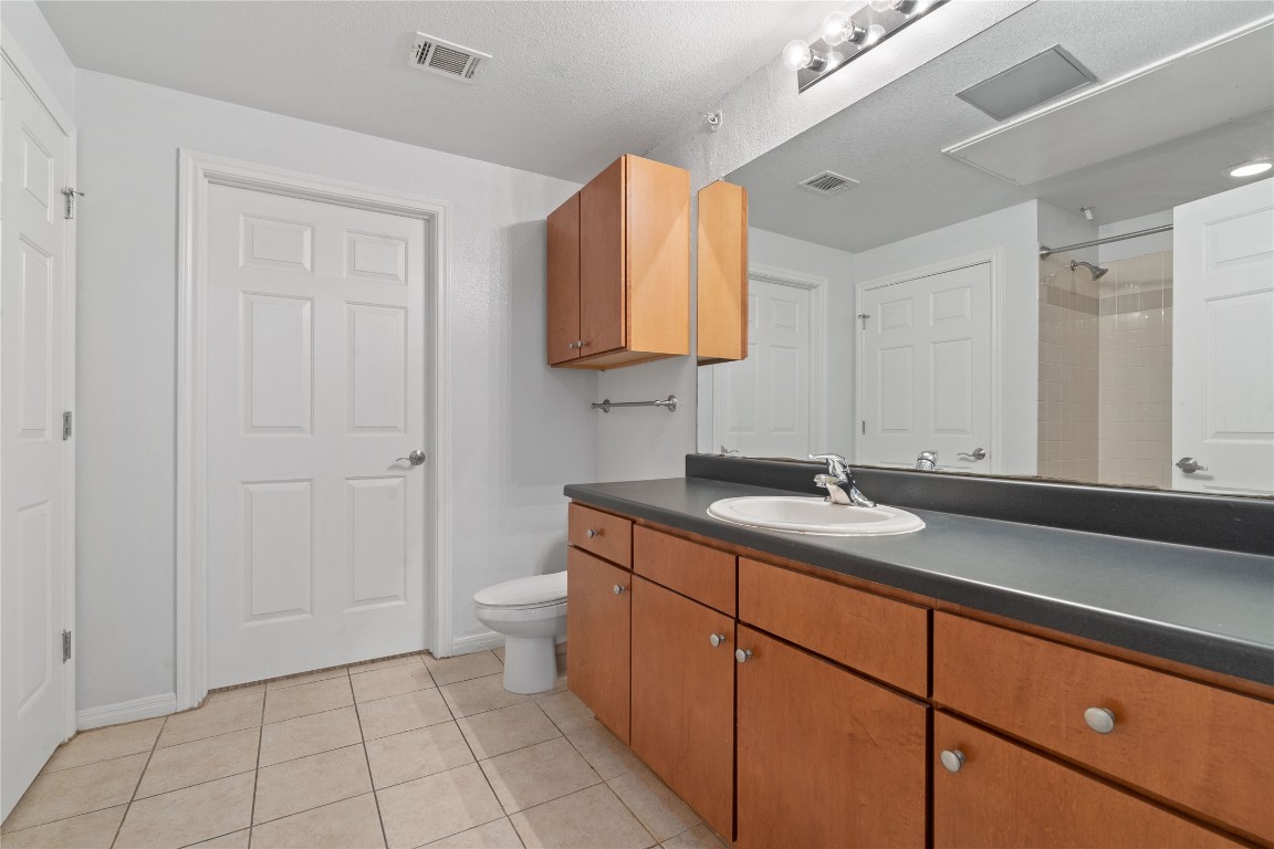 2515 Pearl Street, Unit 508 Austin, TX 78705 - Photo 9 of 25 Full bathroom featuring light tile patterned flooring, vanity, and a shower
