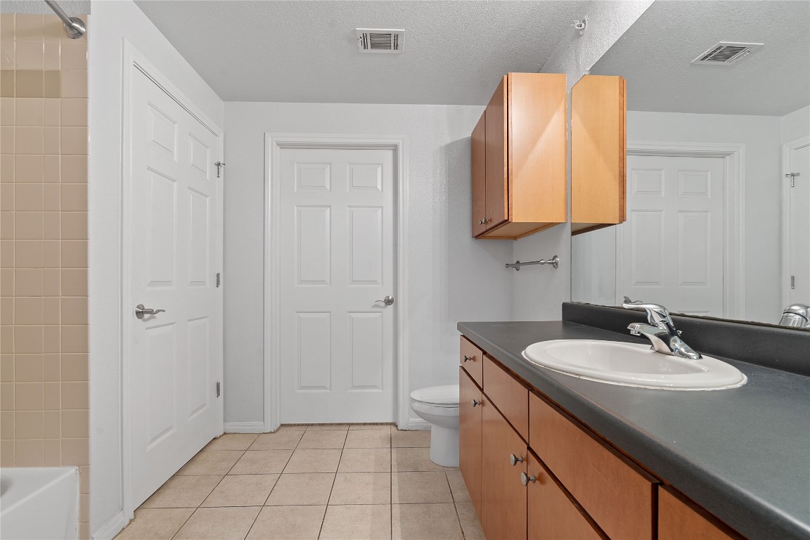 2515 Pearl Street, Unit 508 Austin, TX 78705 - Photo 10 of 25 Full bathroom with light tile patterned flooring, vanity, a textured ceiling, and tub / shower combination