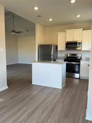 a kitchen with stainless steel appliances a stove top oven a sink and a refrigerator