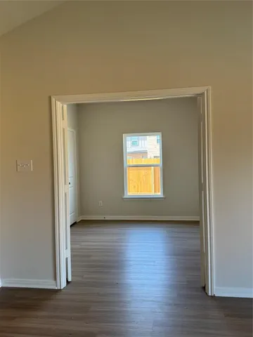 an empty room with wooden floor and a window