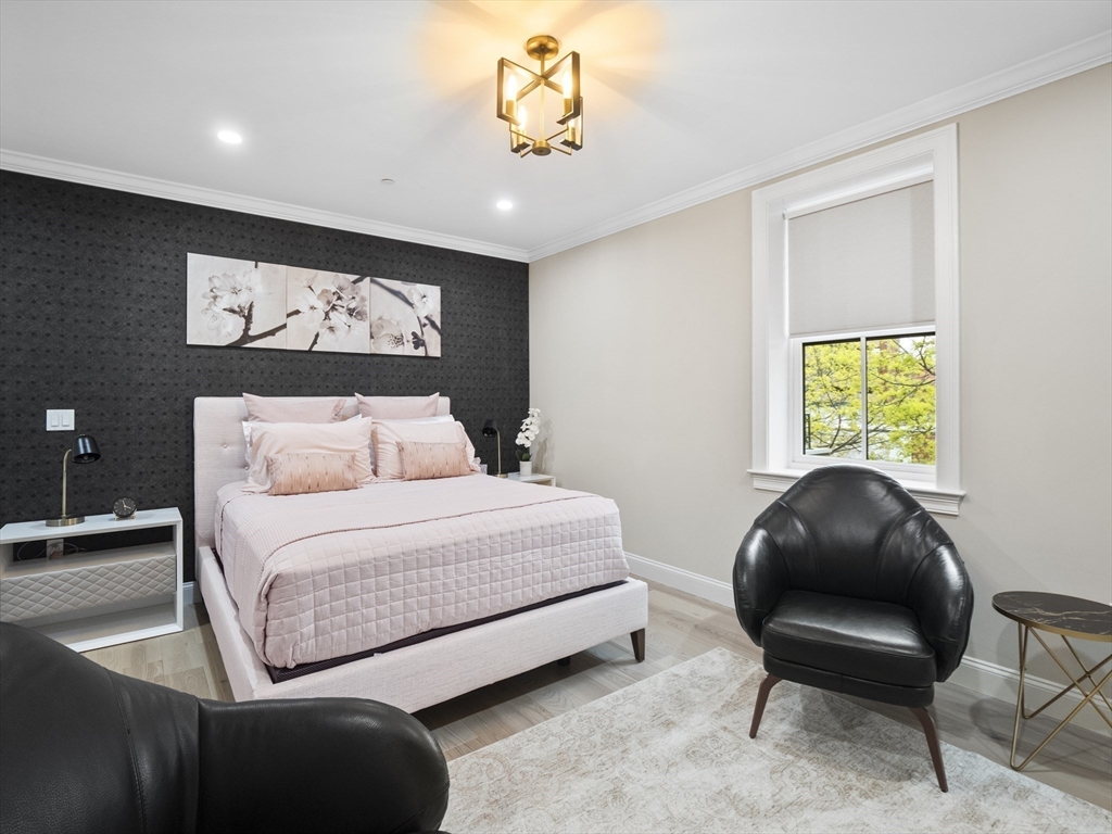 140 Middlesex Street, Unit 3 Lowell, MA 01852 - Photo 13 of 30 a bedroom with a bed and a chair