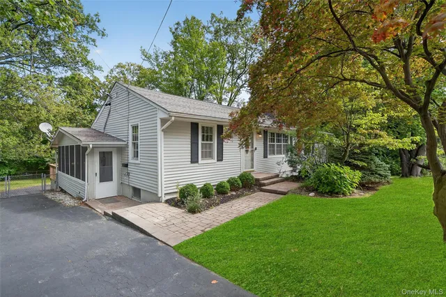 a front view of a house with a garden and yard