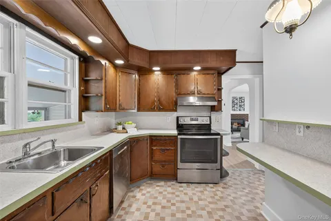 a kitchen with stainless steel appliances granite countertop a sink a stove and a refrigerator