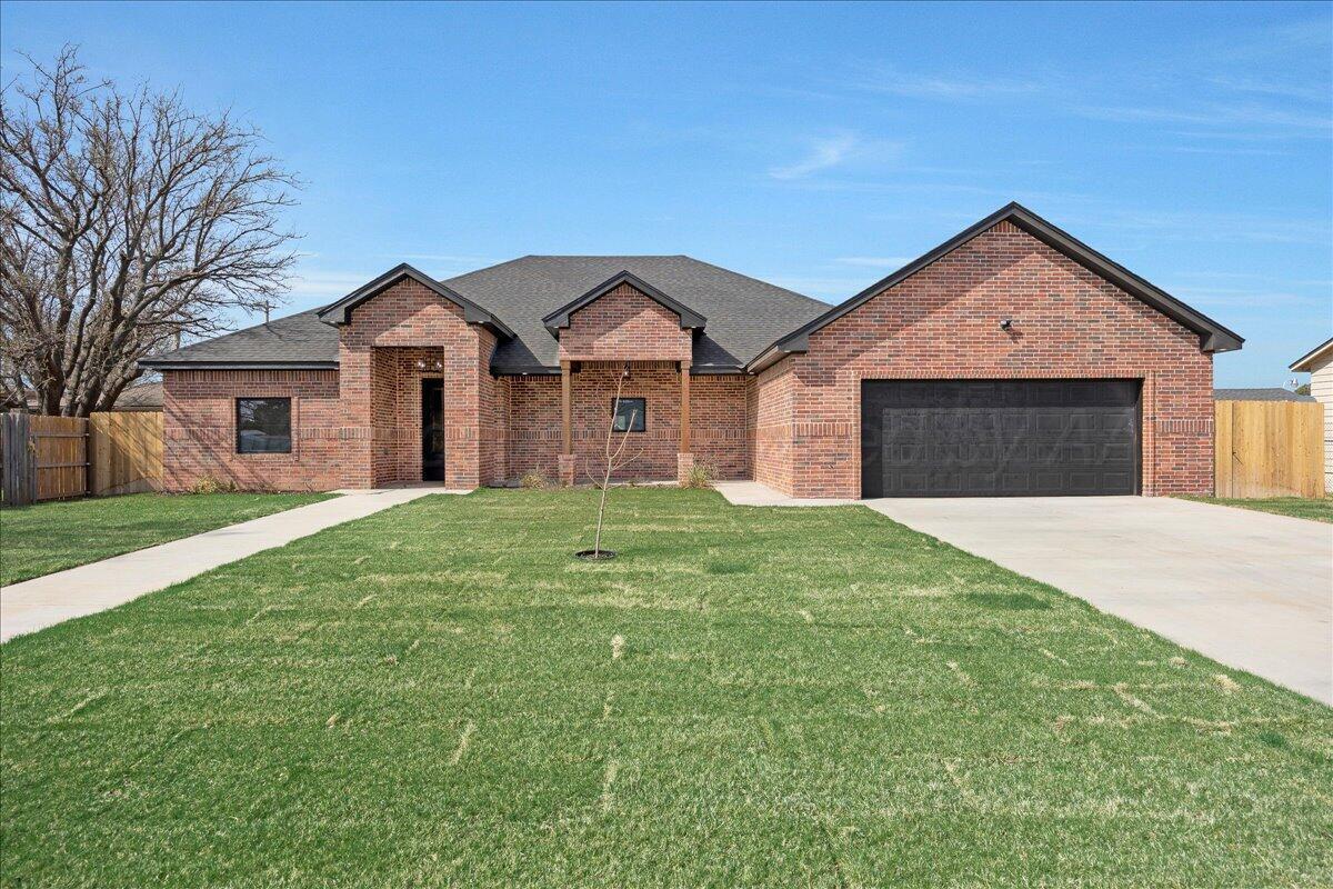 a view of a house with a yard and large tree