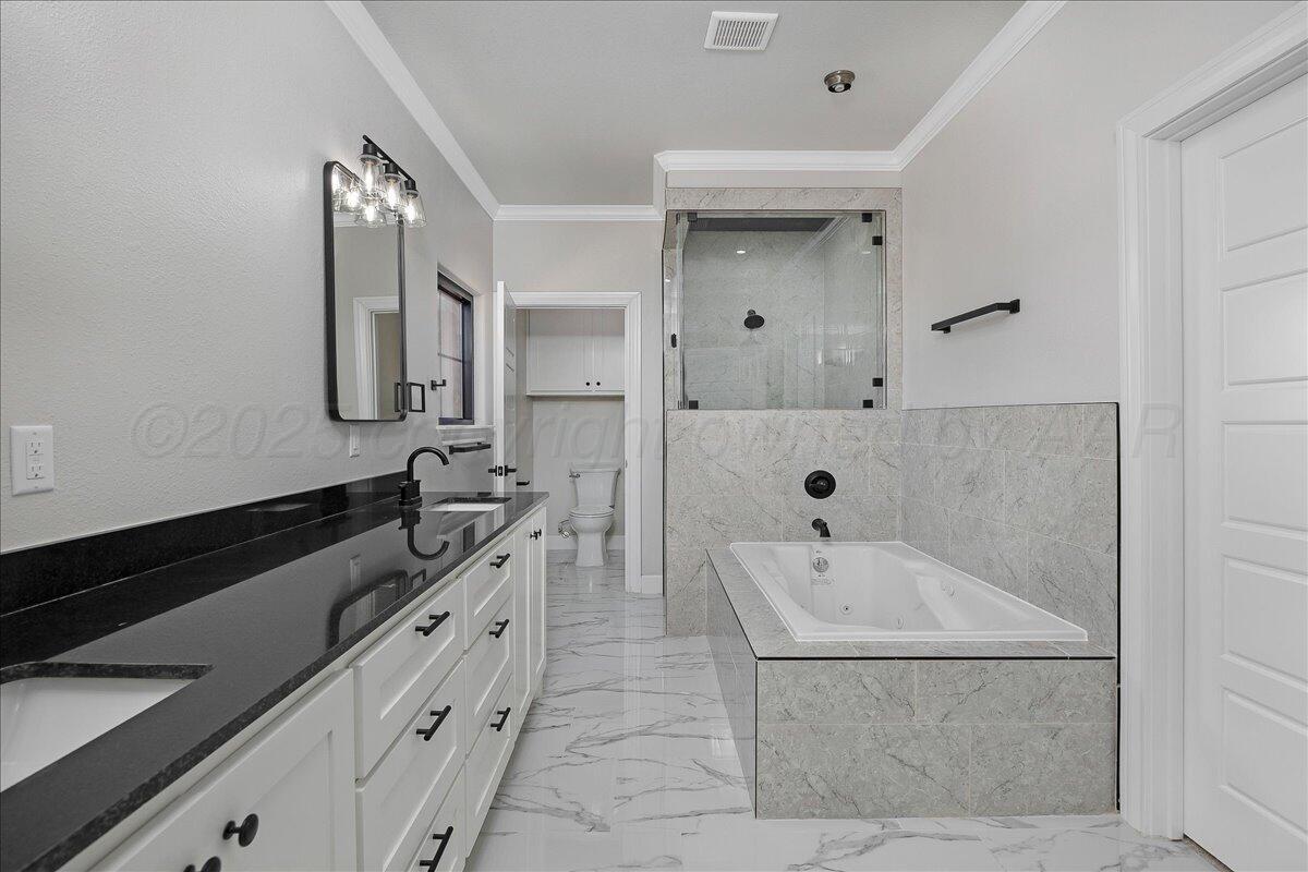 907 Oak Avenue Panhandle, TX 79068 - Photo 15 of 30 a bathroom with a double vanity sink a mirror and a bathtub