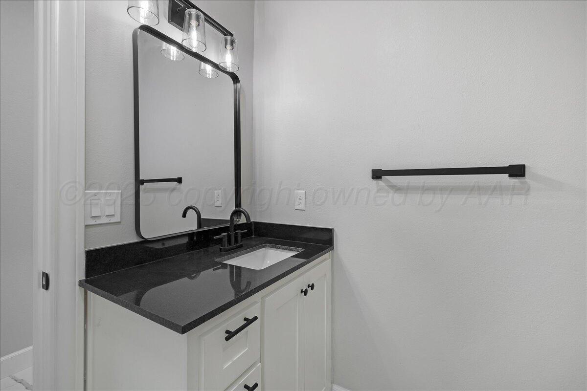 907 Oak Avenue Panhandle, TX 79068 - Photo 25 of 30 a bathroom with a granite countertop sink and a mirror