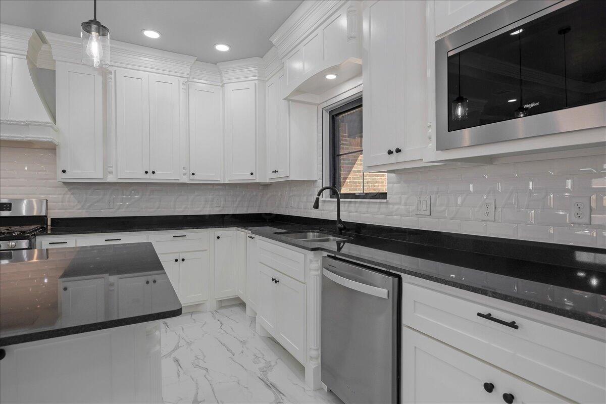 907 Oak Avenue Panhandle, TX 79068 - Photo 10 of 30 a kitchen with granite countertop white cabinets and sink