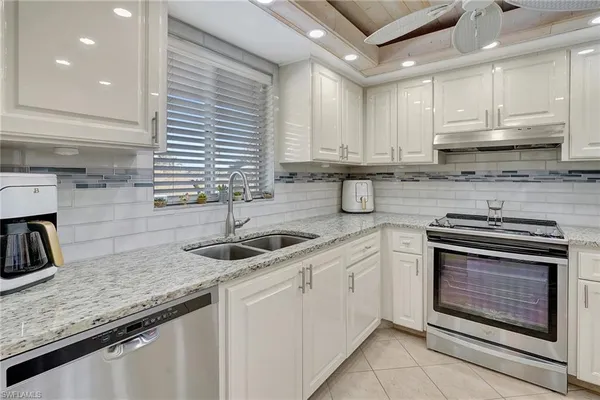 a kitchen with stainless steel appliances granite countertop a sink stove and cabinets