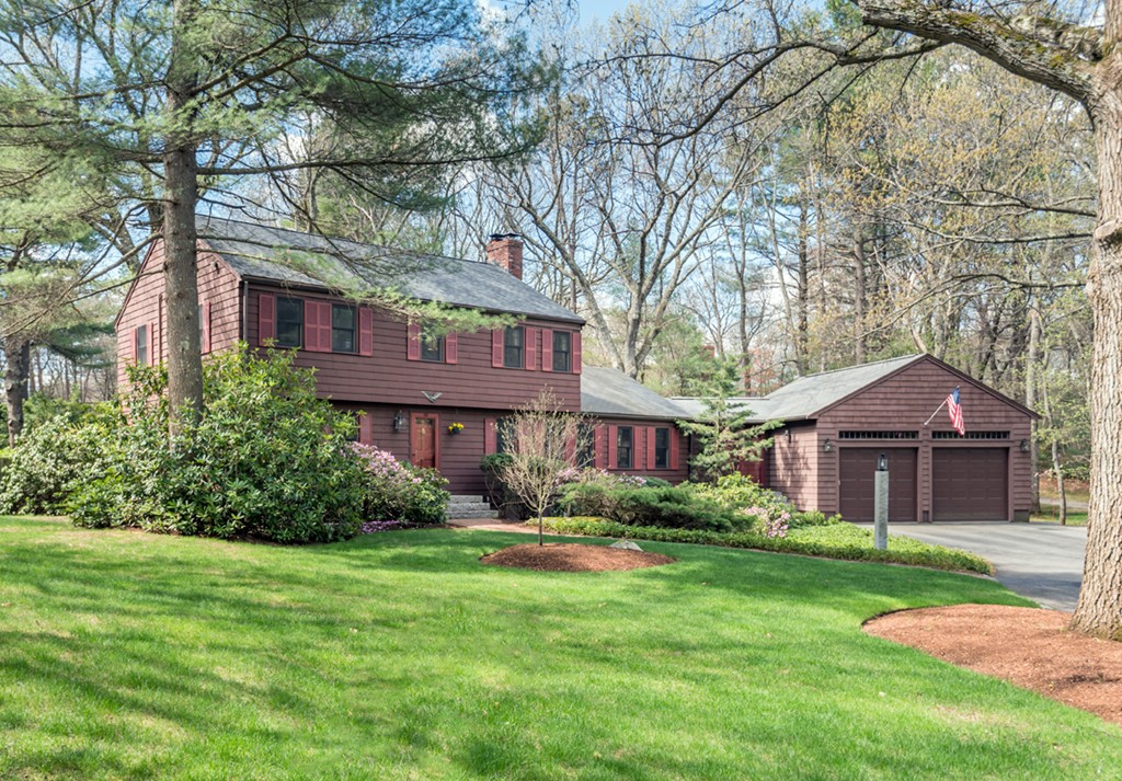 a front view of a house with a yard and trees
