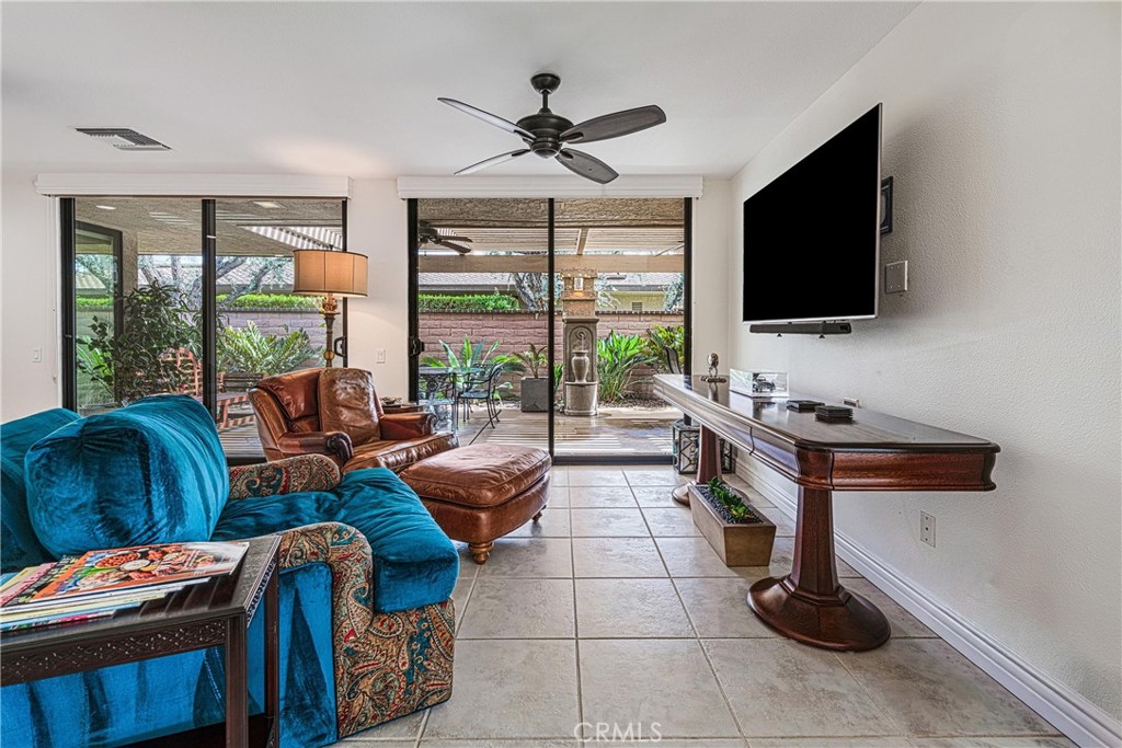 19 Cornell Drive Rancho Mirage, CA 92270 - Photo 11 of 52 a living room with furniture a flat screen tv and a floor to ceiling window