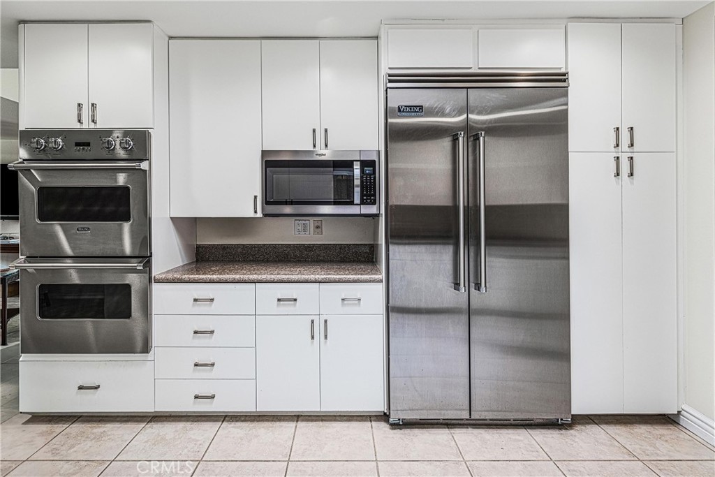 19 Cornell Drive Rancho Mirage, CA 92270 - Photo 16 of 52 a kitchen with a refrigerator and a stove top oven