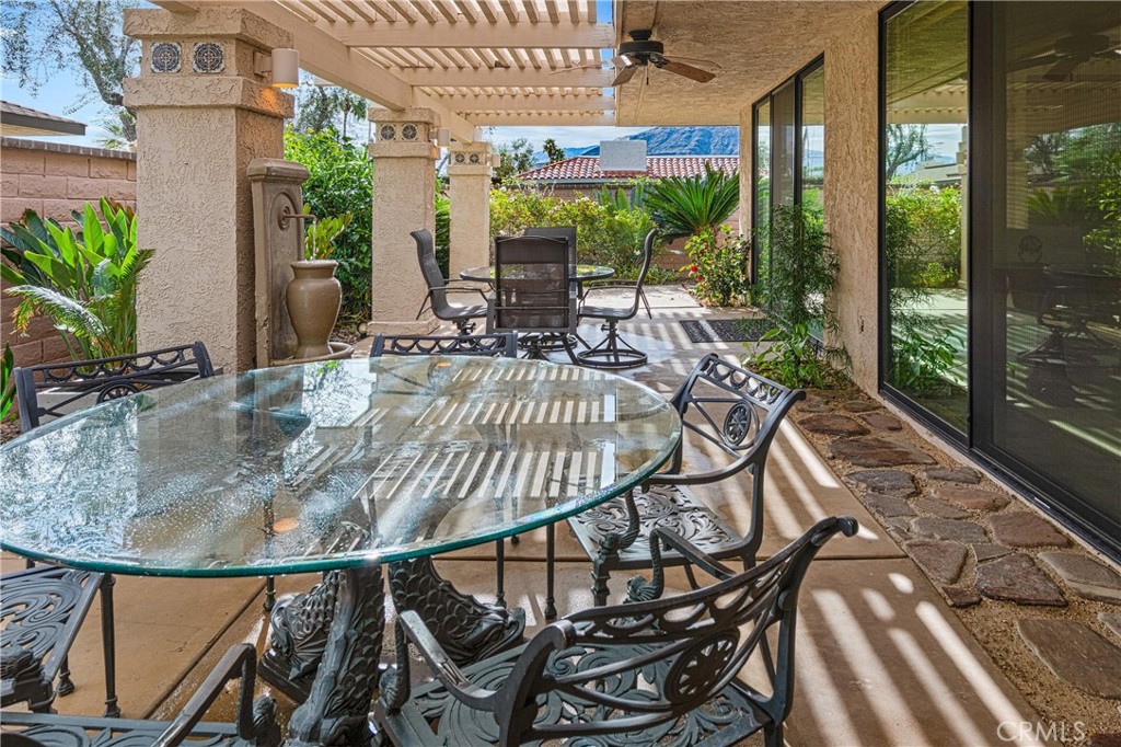 19 Cornell Drive Rancho Mirage, CA 92270 - Photo 26 of 52 a view of a patio with table and chairs potted plants with floor to ceiling window