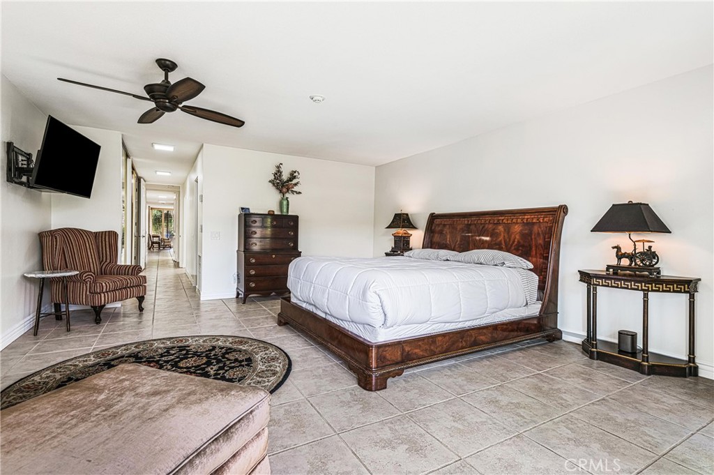 19 Cornell Drive Rancho Mirage, CA 92270 - Photo 30 of 52 a bedroom with a bed a couch and a flat screen tv