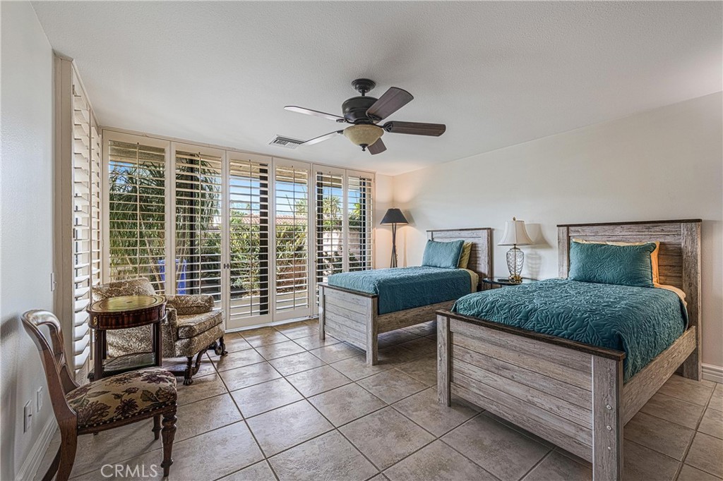 19 Cornell Drive Rancho Mirage, CA 92270 - Photo 34 of 52 a bedroom with a bed and a chandelier