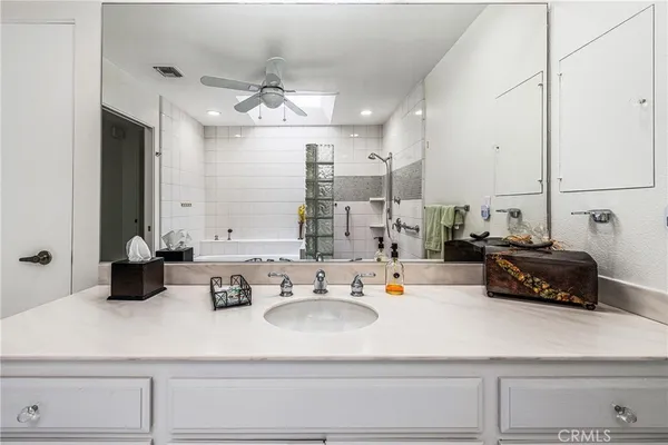 a bathroom with a tub sink and mirror