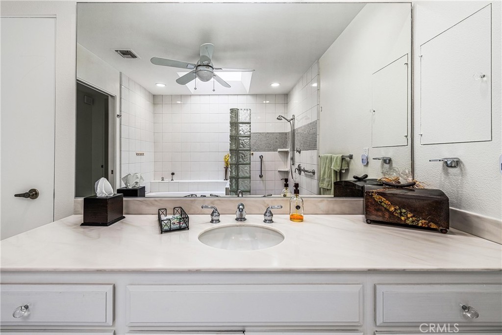 19 Cornell Drive Rancho Mirage, CA 92270 - Photo 35 of 52 a kitchen with a sink dishwasher and white cabinets with wooden floor
