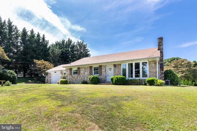a front view of a house with a yard and trees