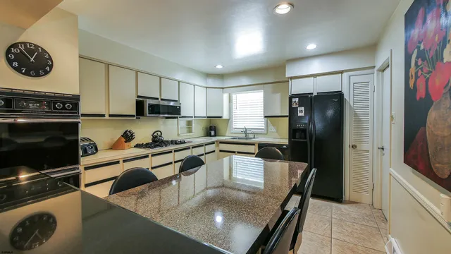 a kitchen with a refrigerator a stove a sink and cabinets