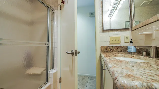 a bathroom with a granite countertop sink and a mirror