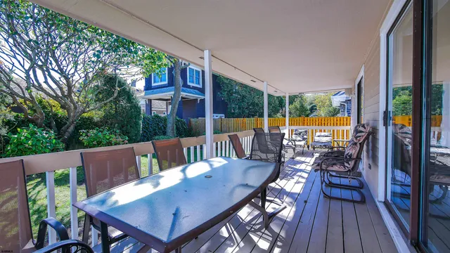 a view of deck with a table and chairs next to a large window with wooden floor
