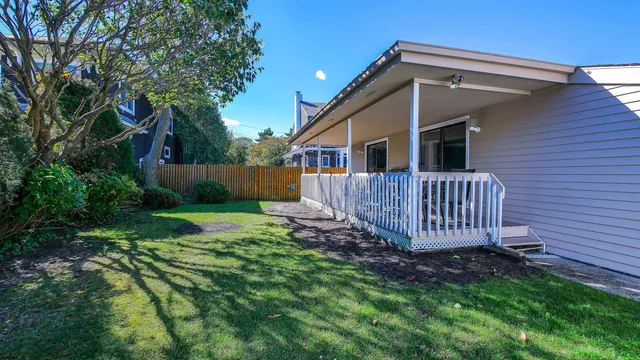 a view of a house with a yard and deck
