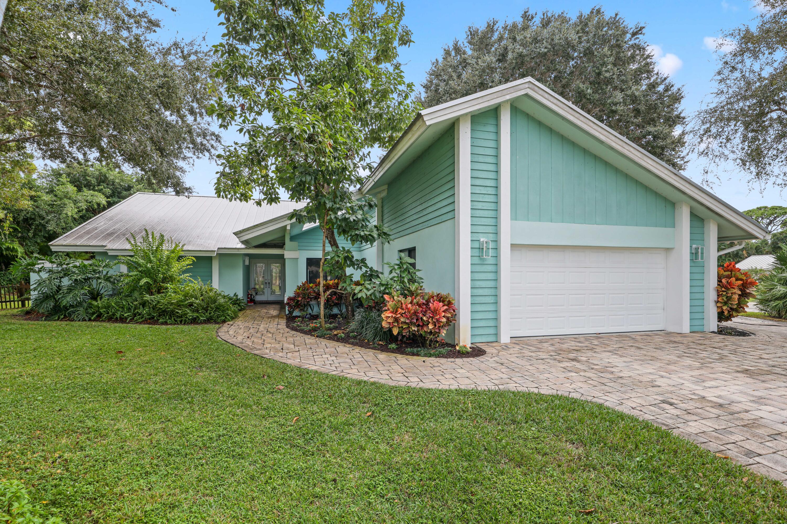 a view of a house with a yard and potted plants