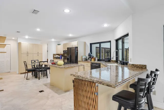 a kitchen with white cabinets and sink