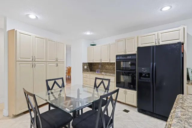 a kitchen with stainless steel appliances kitchen island granite countertop a refrigerator and cabinets