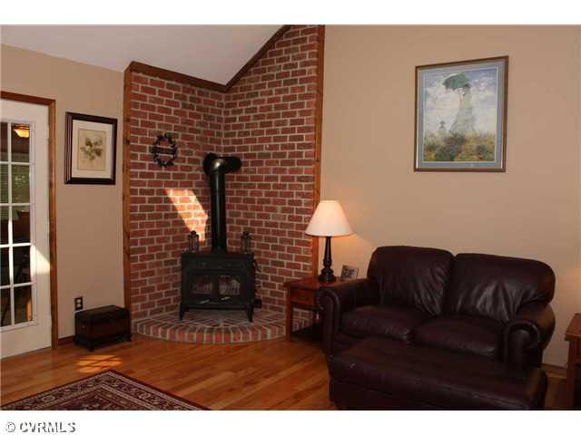 12103 Chatham Road Prince George, VA 23875 - Photo 14 of 18 Living Room - Another view of living room showing wood stove and vaulted line of ceiling.