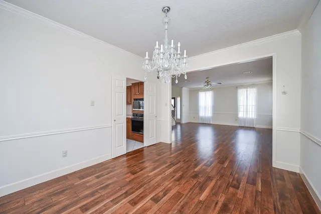 a view of a room with wooden floor and large windows