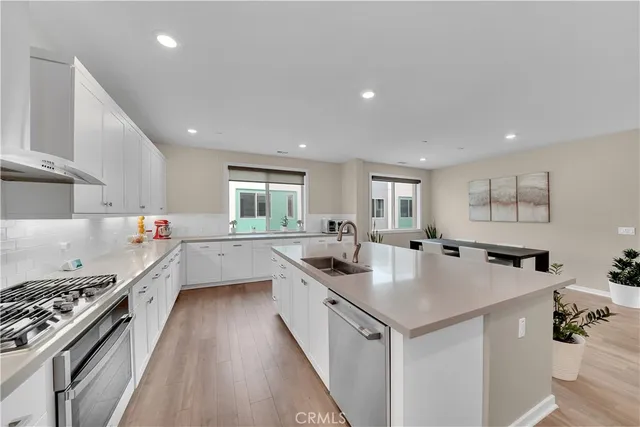 a kitchen that has a lot of cabinets a sink and wooden floor