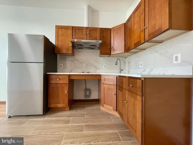 a kitchen with stainless steel appliances granite countertop a refrigerator a stove and a sink