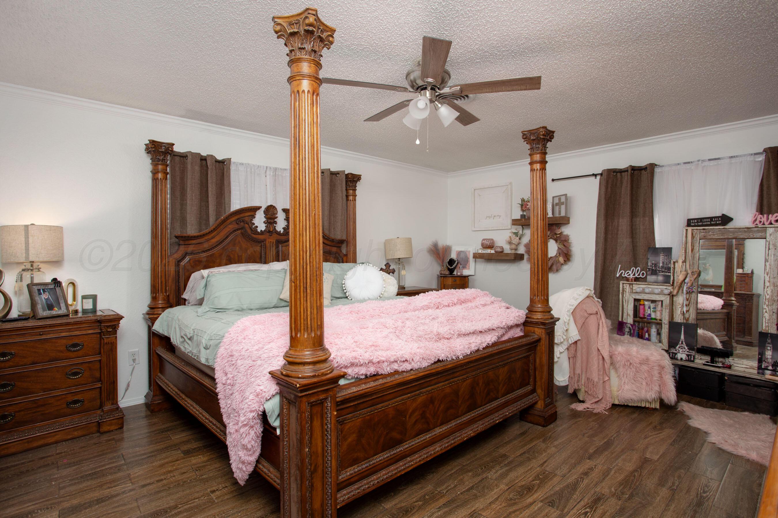 2907 Mable Drive Canyon, TX 79015 - Photo 14 of 23 a bedroom with a bed a chandelier and flat screen tv