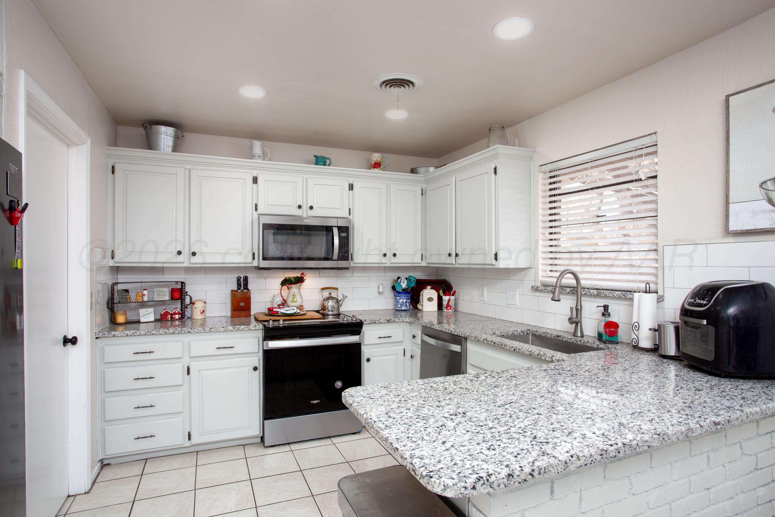 2907 Mable Drive Canyon, TX 79015 - Photo 3 of 23 a kitchen with granite countertop a sink stainless steel appliances and cabinets