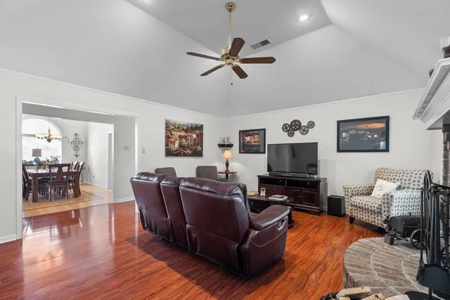 a living room with furniture and a flat screen tv with wooden floor